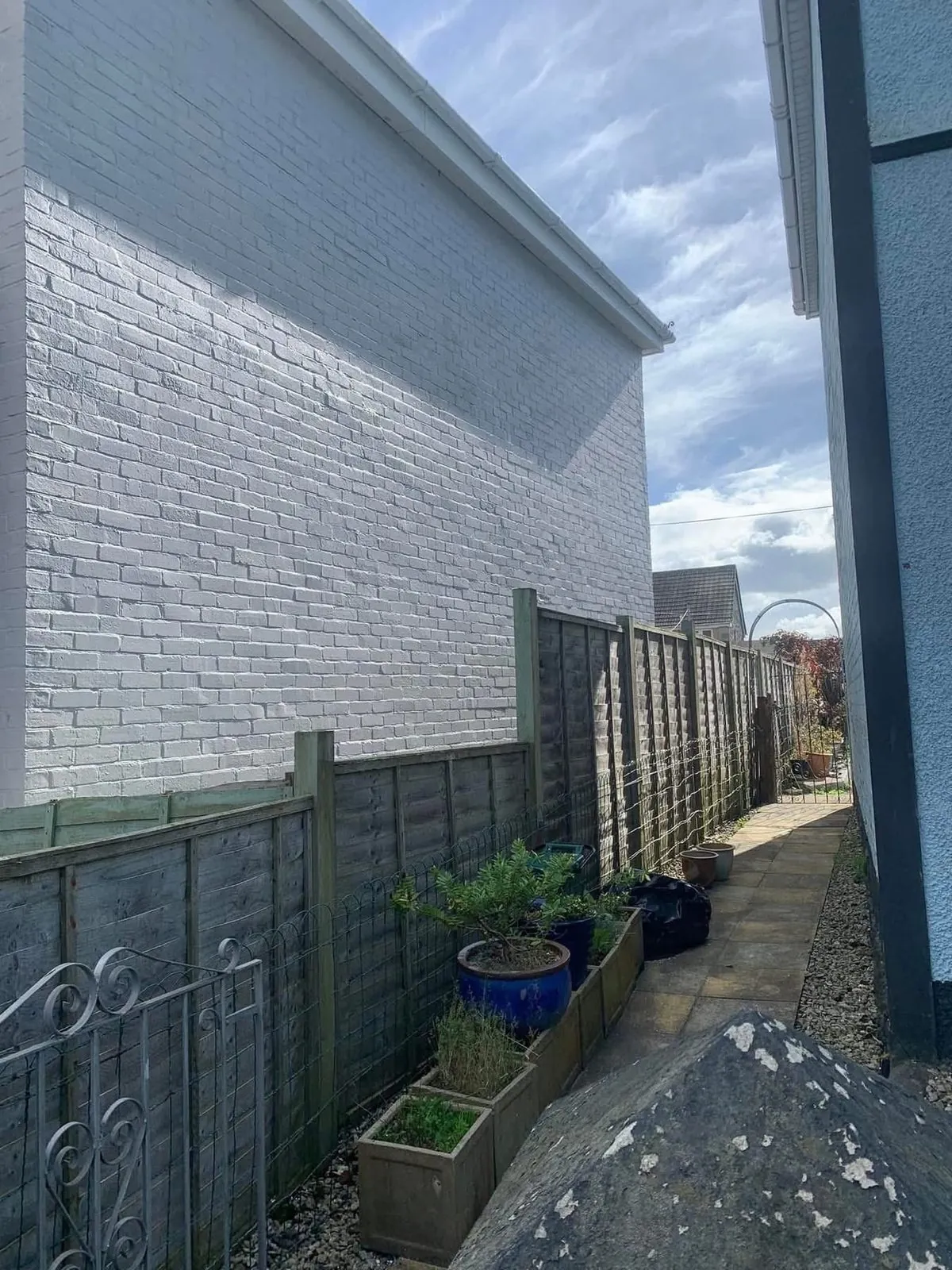 Freshly painted brick wall after preparation and masonry paint in Redruth